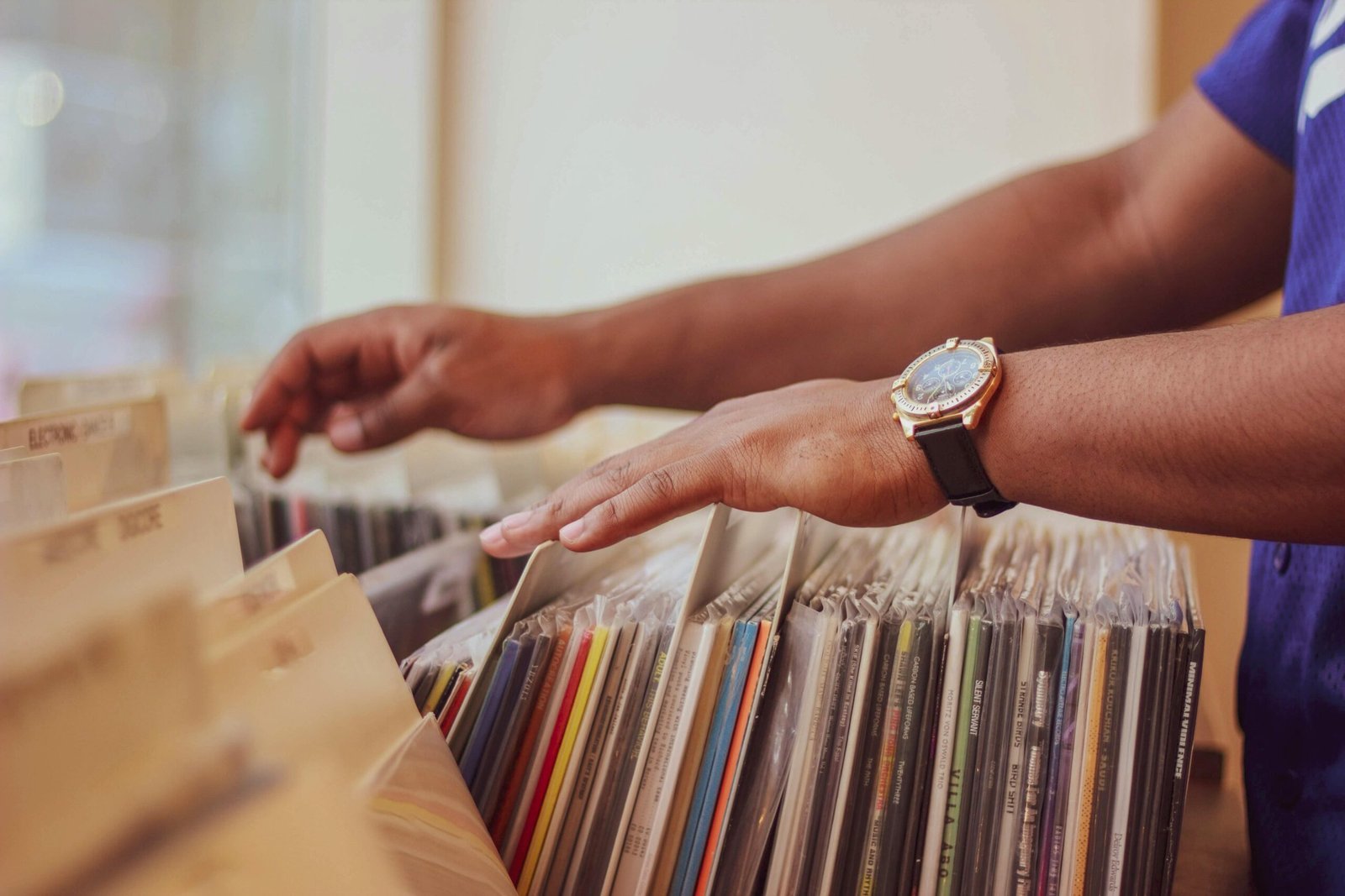 Close-up of hands browsing vinyl records in a store, showcasing a classic vintage collection.